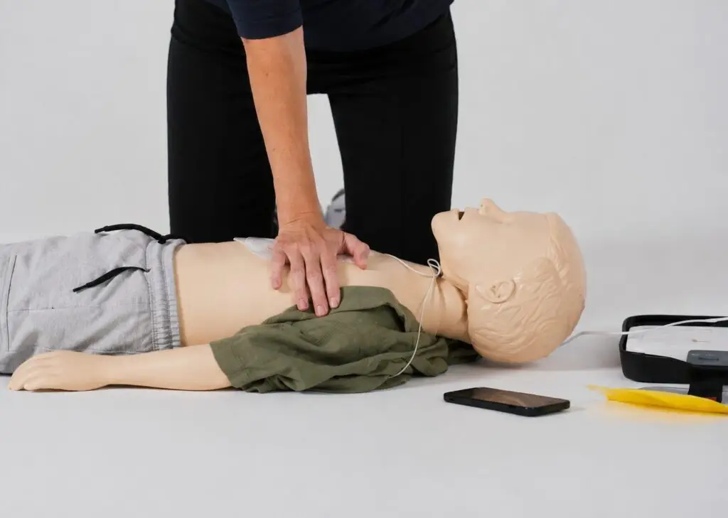 Opfris- en vervolgtraining Reanimatie baby's en kinderen (PBLS): instructeur toont kinderreanimatie op een junior oefenpop
